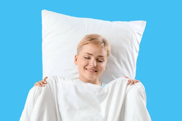 Yumuşak Battaniyeli Yastıklı Genç Kadın Mavi Arka Planda Uyuyor — Stok fotoğraf