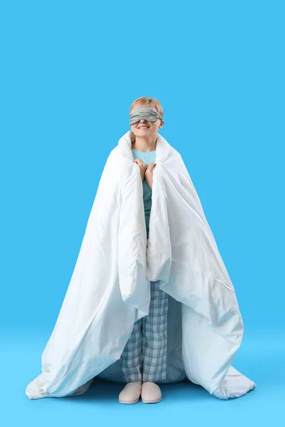 Молодая Женщина Маске Сна Мягким Одеялом Синем Фоне — стоковое фото