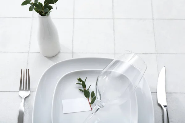 白色瓷砖背景的玻璃卡和空白卡片的格式化餐桌设置 — 图库照片