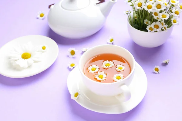 Teekanne Mit Natürlichem Kamillentee Und Blumen Auf Fliederfarbenem Hintergrund — Stockfoto
