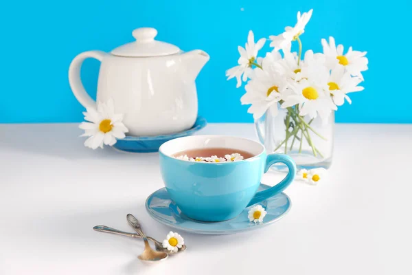 Τσαγιέρα Φλιτζάνι Φυσικό Χαμομήλι Και Λουλούδια Λευκό Τραπέζι Κοντά Μπλε — Φωτογραφία Αρχείου