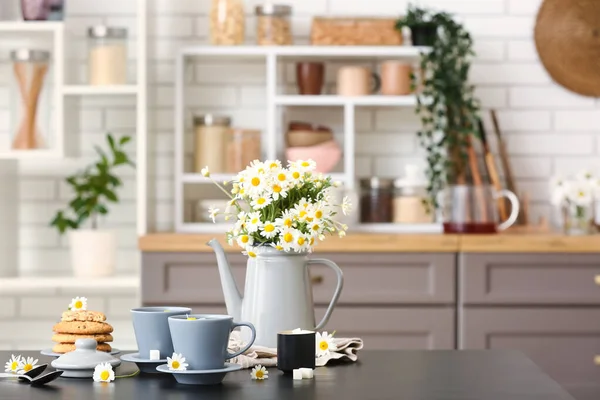 Ποτιστήρι Λουλούδια Φλυτζάνια Από Φυσικό Χαμομήλι Και Μπισκότα Μαύρο Τραπέζι — Φωτογραφία Αρχείου