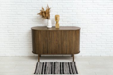 Çimenli ahşap çekmeceler ve hafif tuğlalı duvarın yanında dekorasyon.