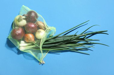 Mavi arka planda farklı türde soğan içeren yankı torbası.