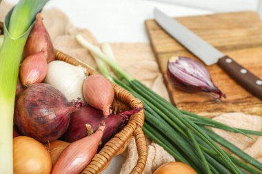 Hasır sepet. Masada farklı çeşit soğan var. Yakın plan.