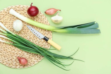 Yeşil zemin üzerinde farklı soğan çeşitleri olan hasır bir hasırdır.