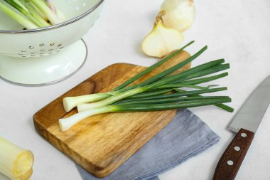 Açık arkaplanda yeşil soğanlı tahta, yakın plan