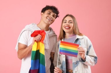 Pembe arka planda LGBT bayrakları olan genç bir çift