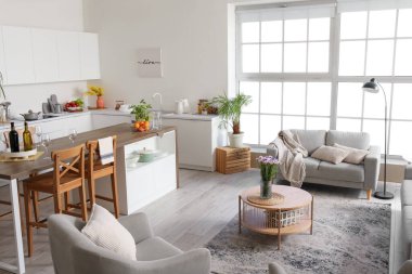 Açık mutfak planı, kahve masası ve gri kanepe.