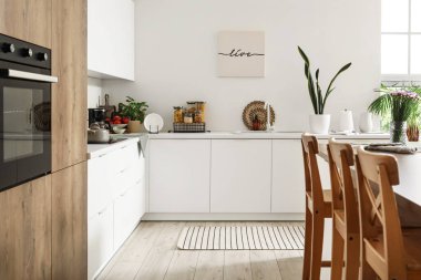 Beyaz tezgahlı, adalı ve entegre fırınlı aydınlık mutfağın içi