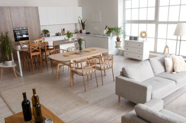 Açık mutfak, yemek masası, ada ve gri kanepe.