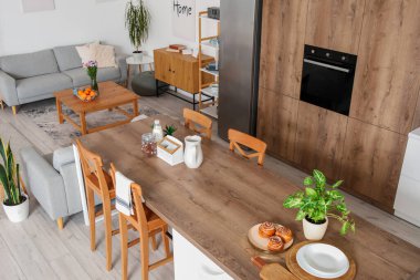 Ada masası ve gri koltukları olan açık planlı bir mutfak.