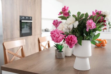 Modern mutfaktaki masasında güzel şakayık çiçekleri olan vazo.