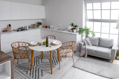 Yemek masası ve gri kanepesi olan açık mutfak planı.