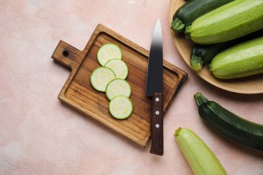 Hafif arka planda taze kabak dilimleri olan ahşap tahta.