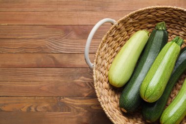 Tahta arka planda yeşil kabaklı sepet.