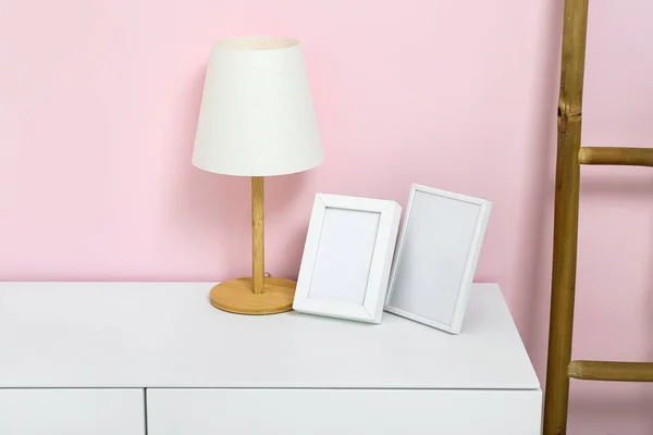 Λευκό Συρταριέρα Λάμπα Λευκές Εικόνες Και Σκάλα Κοντά Ροζ Τοίχο — Φωτογραφία Αρχείου