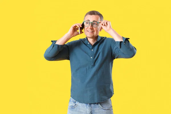 Mature Man Eyeglasses Talking Mobile Phone Yellow Background — Stock Photo, Image