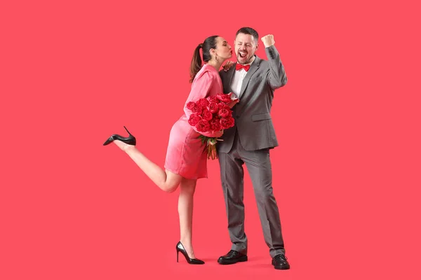 Joven Proponiéndole Matrimonio Novia Con Flores Sobre Fondo Rojo —  Fotos de Stock