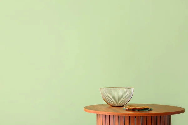 緑の壁の近くに金属製のボウル木製のコーヒーテーブル — ストック写真
