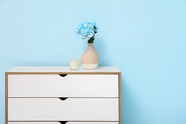 Κομψό Λευκό Συρταριέρα Λουλούδια Παιώνιες Και Λαμπάδα Κοντά Μπλε Τοίχο — Φωτογραφία Αρχείου