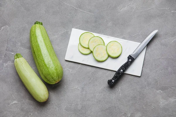 Platte Mit Schnitt Und Ganzen Zucchini Auf Grauem Hintergrund — Stockfoto