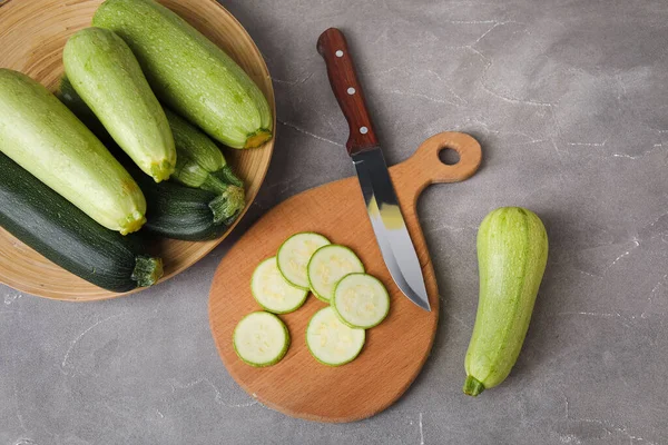 Brett Mit Scheiben Und Teller Frischer Grüner Zucchini Auf Grauem — Stockfoto