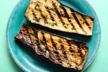 Turkuaz arka planda leziz ızgara patlıcan tabağı, yakın plan.