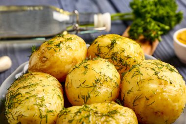 Bir tabak haşlanmış maydanozlu bebek patates, yakın plan.