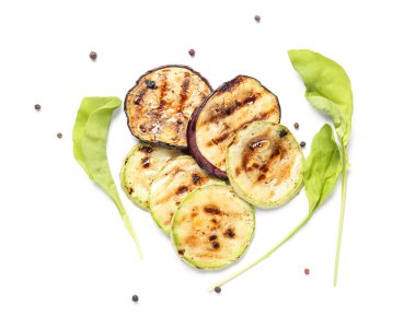 Beyaz arka planda ızgara kabak ve patlıcan dilimleri.