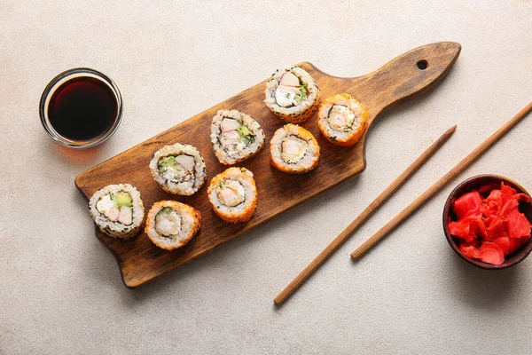 Stock image Tasty sushi rolls, soy sauce and ginger on light background