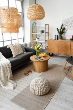 Büyük pencerenin yanında rahat kanepesi ve sehpası olan şık bir oturma odası.