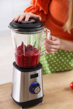 Mutfakta blender ile pancar suyu yapan genç kadın, yakın plan.