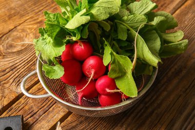Ahşap arka planda taze turplu kolander.