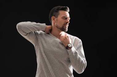 Genç adam siyah arka planda panik atak geçiriyor.