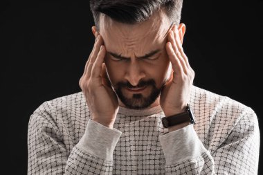 Siyah arka planda panik atak geçiren genç adam, yakın plan.