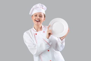 Gri arka plan üzerinde boş plaka ile kadın Şef