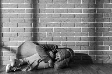 Gri tuğla duvarın yanında yatan genç bir kadını dövmüş. Aile içi şiddet kavramı