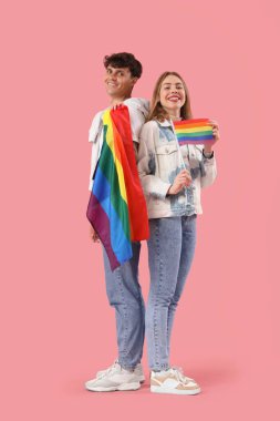 Pembe arka planda LGBT bayrakları olan genç bir çift