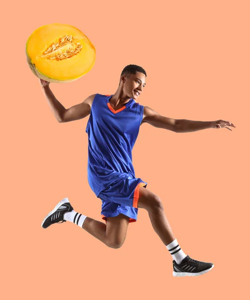 Jumping Jugador Baloncesto Afroamericano Con Jugoso Melón Sobre Fondo Naranja —  Fotos de Stock