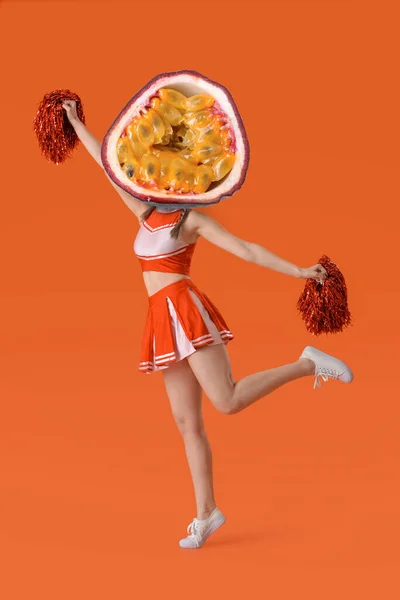 美しいですチアリーダーでエキゾチックな情熱の果物代わりに彼女の頭でオレンジの背景 — ストック写真