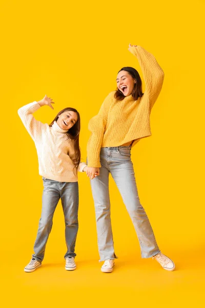 Κοριτσάκι Και Μητέρα Της Πλεκτά Πουλόβερ Χορεύουν Κίτρινο Φόντο — Φωτογραφία Αρχείου