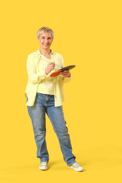 Ältere Weibliche Künstlerin Mit Werkzeugen Auf Gelbem Hintergrund — Stockfoto