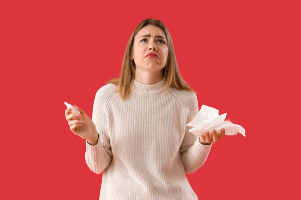 Kranke Junge Frau Mit Nasentropfen Und Gewebe Auf Rotem Hintergrund — Stockfoto
