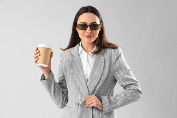 Ung Kvinna Snygg Kostym Med Kopp Kaffe Ljus Bakgrund — Stockfoto