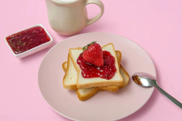 ピンクの背景にピッチャーでイチゴジャムとミルクとおいしいトーストのプレート — ストック写真