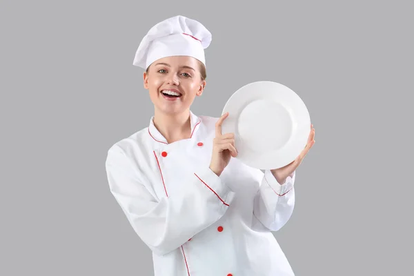 Chef Feminino Com Placa Vazia Fundo Cinza — Fotografia de Stock