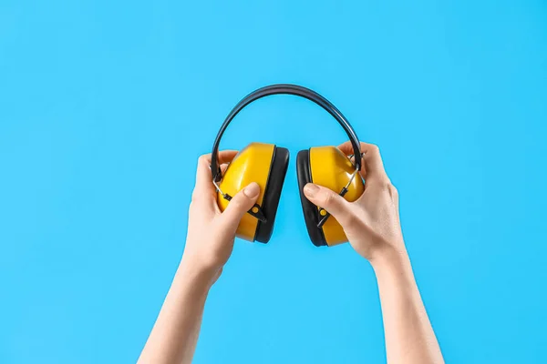 Female Hands Holding Ear Muffs Blue Background — Stock Photo, Image