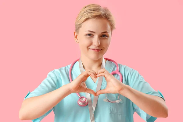 Medizinische Praktikantin Macht Herz Mit Ihren Händen Auf Rosa Hintergrund — Stockfoto