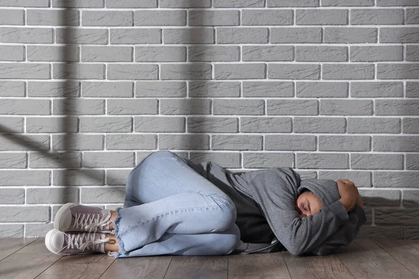 Beaten Young Woman Lying Grey Brick Wall Domestic Violence Concept — Stock Photo, Image